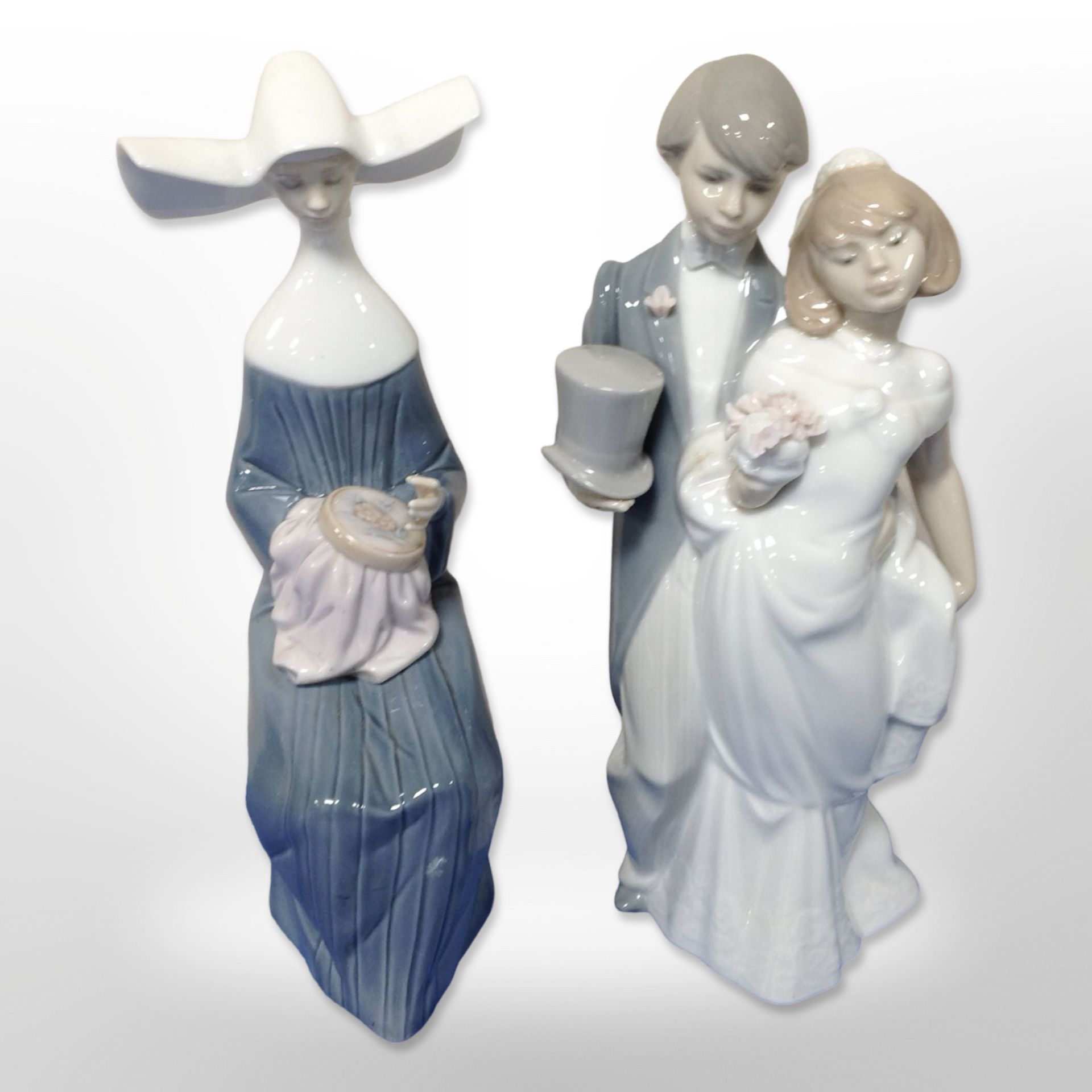 A Lladró figure of a bride and groom, No. 6164, and a further figure of a seated nun, No. 5501.