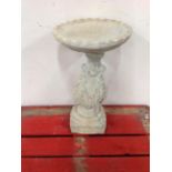 A circular concrete bird bath with acanthus leaf pedestal,