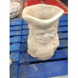 A concrete toby jug planter,