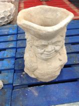 A concrete toby jug planter,