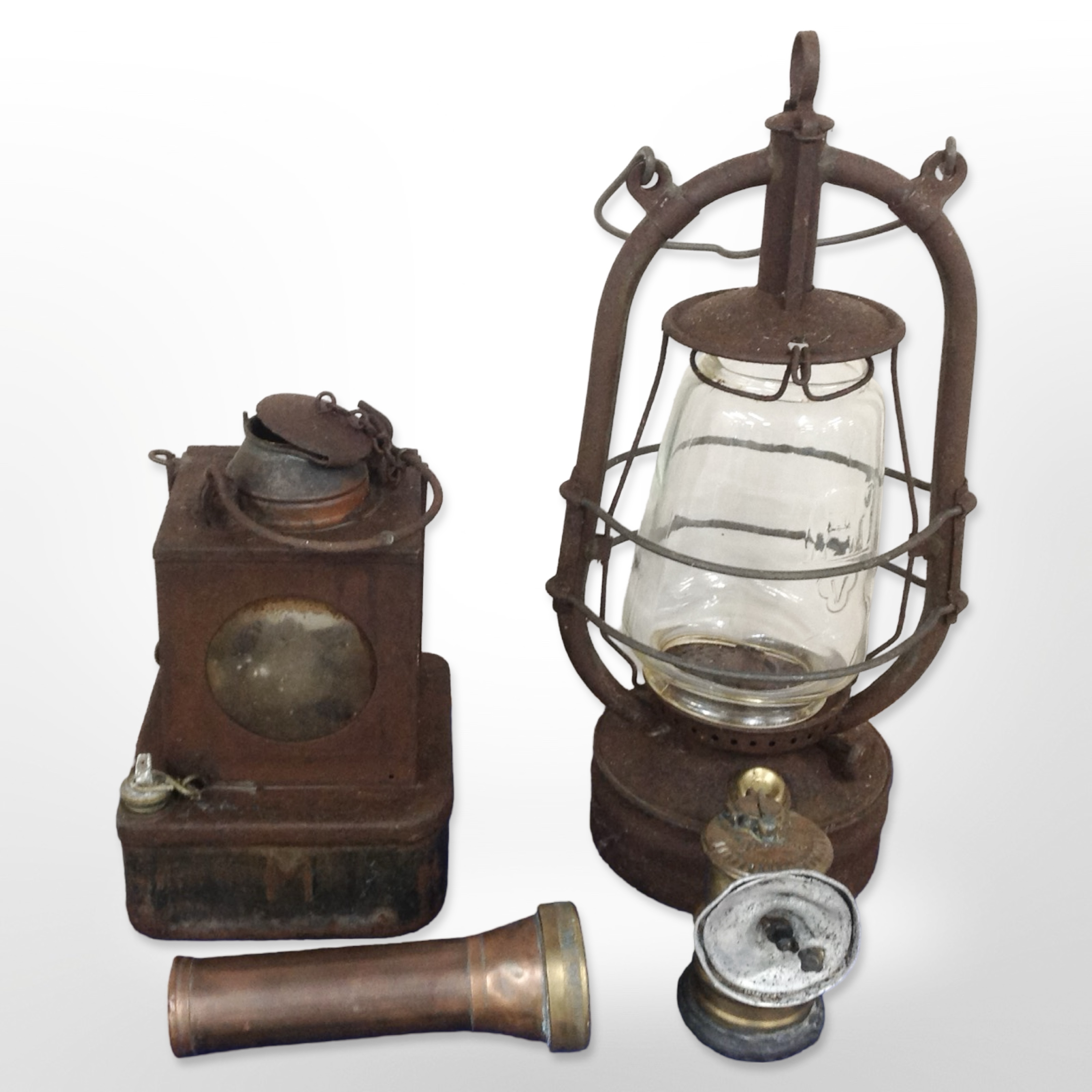 A copper and brass Concordia torch, a Premier bicycle lamp and two further oil lamps.
