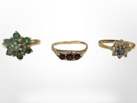 A 9ct gold emerald cluster ring, similar garnet ring and another cluster ring stamped Silver.