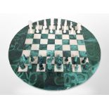 A polished malachite circular chessboard and pieces, diameter 40cm.