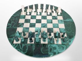 A polished malachite circular chessboard and pieces, diameter 40cm.
