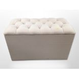 A contemporary storage ottoman in buttoned upholstery, width 91cm.