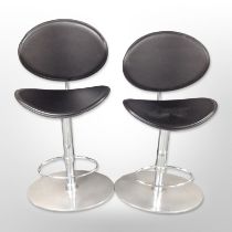 A pair of contemporary chrome and black stitched vinyl adjustable bar stools.