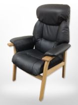 A contemporary Scandinavian oak-framed black leather armchair.