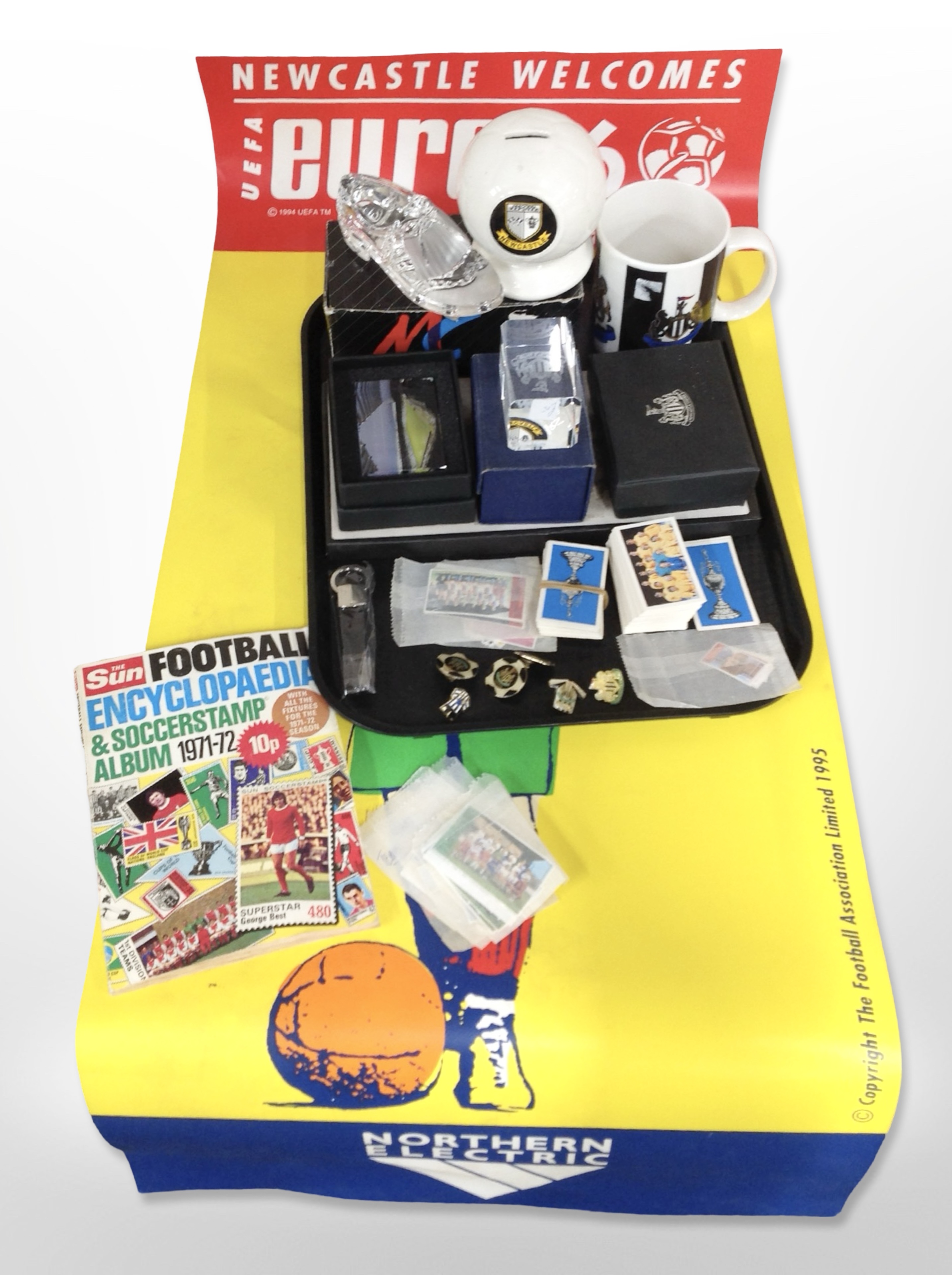 A group of Newcastle United collectibles including paperweights, enamelled badges, money box, mug,
