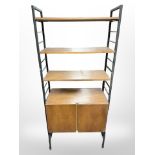 A teak and metal-framed adjustable Ladderax shelving unit fitted two cupboards beneath,