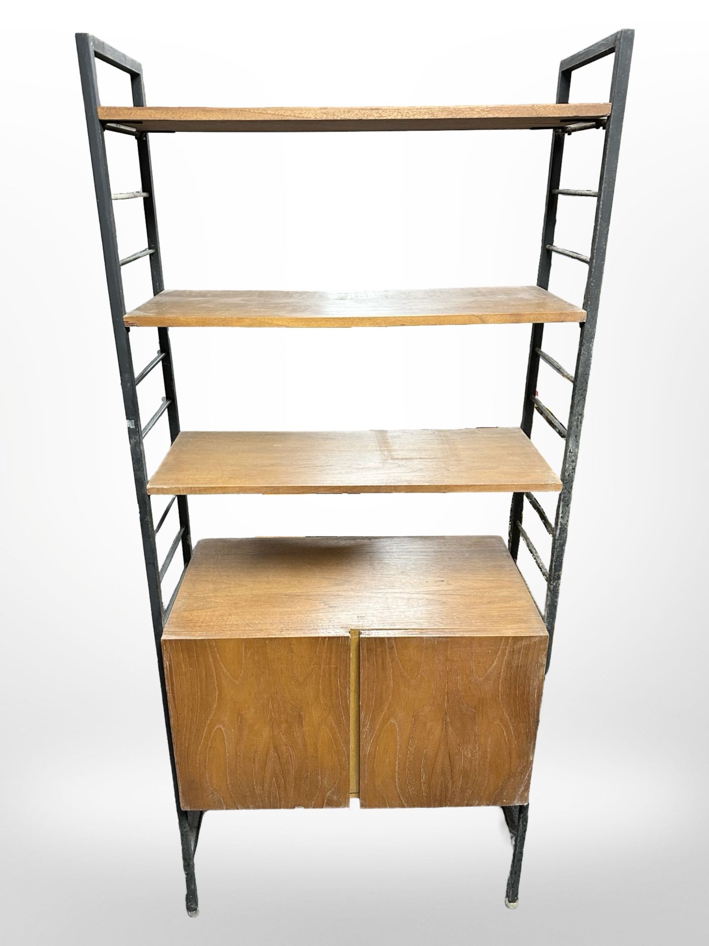 A teak and metal-framed adjustable Ladderax shelving unit fitted two cupboards beneath,