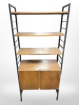 A teak and metal-framed adjustable Ladderax shelving unit fitted two cupboards beneath,