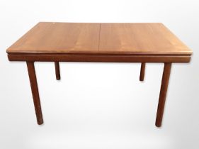 A 20th-century teak extending rectangular dining table with internal leaf,