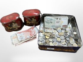 A tin of mixed coins and banknotes, a further pair of tins depicting cats.