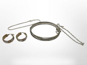 A silver bangle together with a pair of three-tone silver earrings and two silver bracelets.