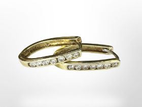 A pair of 14ct gold earrings channel set with diamonds, length 2cm.