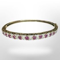 A 9ct gold ruby and diamond bangle, inner diameter 6cm. CONDITION REPORT: 10.