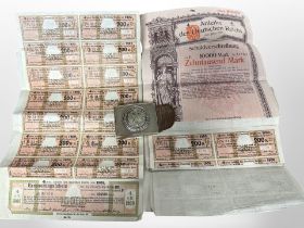 A collection of German bonds, together with a West German nickel belt buckle.