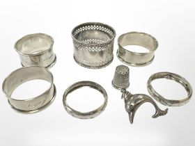 A group of silver items including dophin pendant, thimble,
