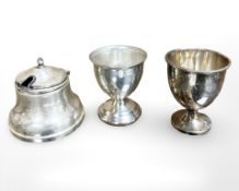 Two silver egg cups, together with a silver salt.
