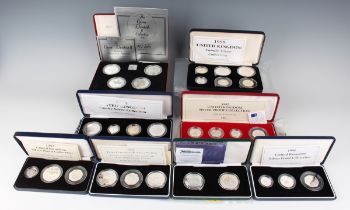 A group of eight Elizabeth II Royal Mint deluxe-cased silver proof coin sets, including United