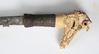 An early 20th century Dayak mandau with curved hatchet-section blade, blade length 52cm, with