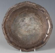 A George VI silver shaped circular card salver, cast with a Celtic design rim, raised on claw and