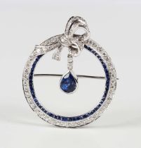 An 18ct gold, sapphire and diamond brooch of circular openwork design with a bow surmount, the