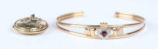 A 9ct gold, garnet and diamond Claddagh bangle, inside width 6.3cm, and a 9ct gold oval pendant