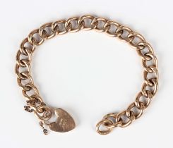 A gold hollow curblink bracelet, detailed '9ct', on a 9ct gold heart shaped padlock clasp, weight