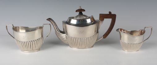 An Edwardian silver bachelor's three-piece tea set of oval half-reeded form, comprising teapot,