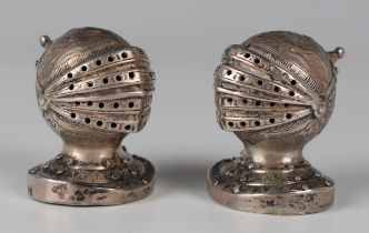 A pair of George V silver novelty pepper casters, each in the form of a knight's helmet with