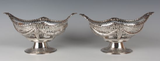 A pair of late Victorian silver baskets, each of oval form with foliate garland and pierced sides