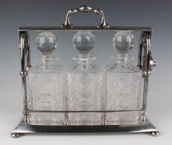 A Mappin & Webb plated three-bottle tantalus with locking mechanism, fitted with three square cut