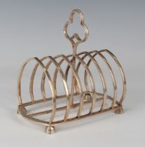 A late Victorian silver six-division toast rack with central trefoil handle, London 1890 by