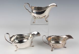 An Edwardian Irish silver sauce boat with foliate capped scroll handle and beaded rim, raised on