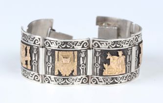 A Peruvian silver and gold panel link bracelet, each square link decorated with deity figures and