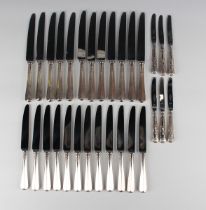 A set of twelve Elizabeth II silver handled table knives and twelve matching dessert knives,