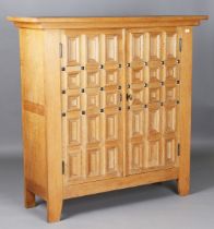 A late 20th century Continental oak side cabinet, the two panelled doors enclosing drawers and