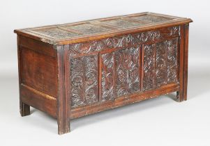 An early 18th century panelled oak coffer with later carved decoration, height 69cm, width 132cm,
