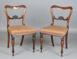 A set of eight early Victorian rosewood spoon back dining chairs with carved foliate centre rails