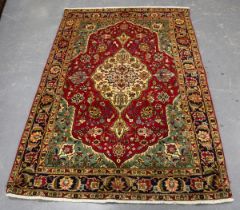 A Tabriz rug, Central Persia, late 20th century, the puce field with an ivory medallion, within a