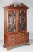 A late 19th century George III style mahogany bookcase-on-chest, the breakarch pediment above