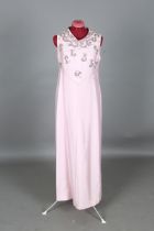 A pale pink dress worn by Dame Vera Lynn, the body with beadwork appliqué, the interior label