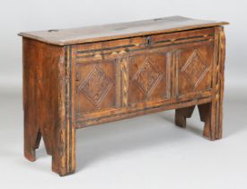 A 17th century oak panel front coffer, the lid with original wire hinges, the front with carved