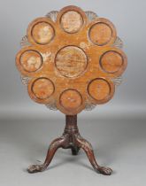 A George III and later carved tip-top supper table, the lobed circular top carved with nine