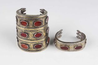 A Tekke silver parcel gilt and cornelian set cuff bangle, 19th century, decorated with three bands