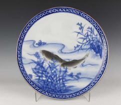 A Japanese Arita blue and white circular charger dish, early 20th century, painted with a pair of