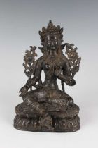 A Sino-Tibetan brown patinated bronze figure of Tara, probably late Qing dynasty, modelled seated in