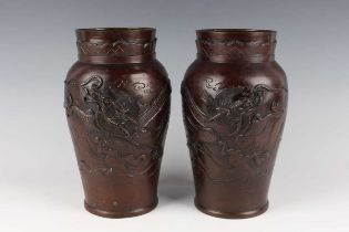 A pair of Japanese bronze vases, Meiji/Taisho period, of shouldered tapering form, cast in relief