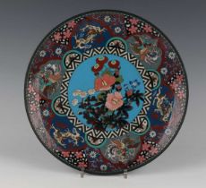 A Japanese cloisonné circular dish, Meiji period, decorated with a central floral panel against a